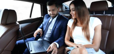 Genç iş adamları bir taksinin arka koltuğunda oturuyor.