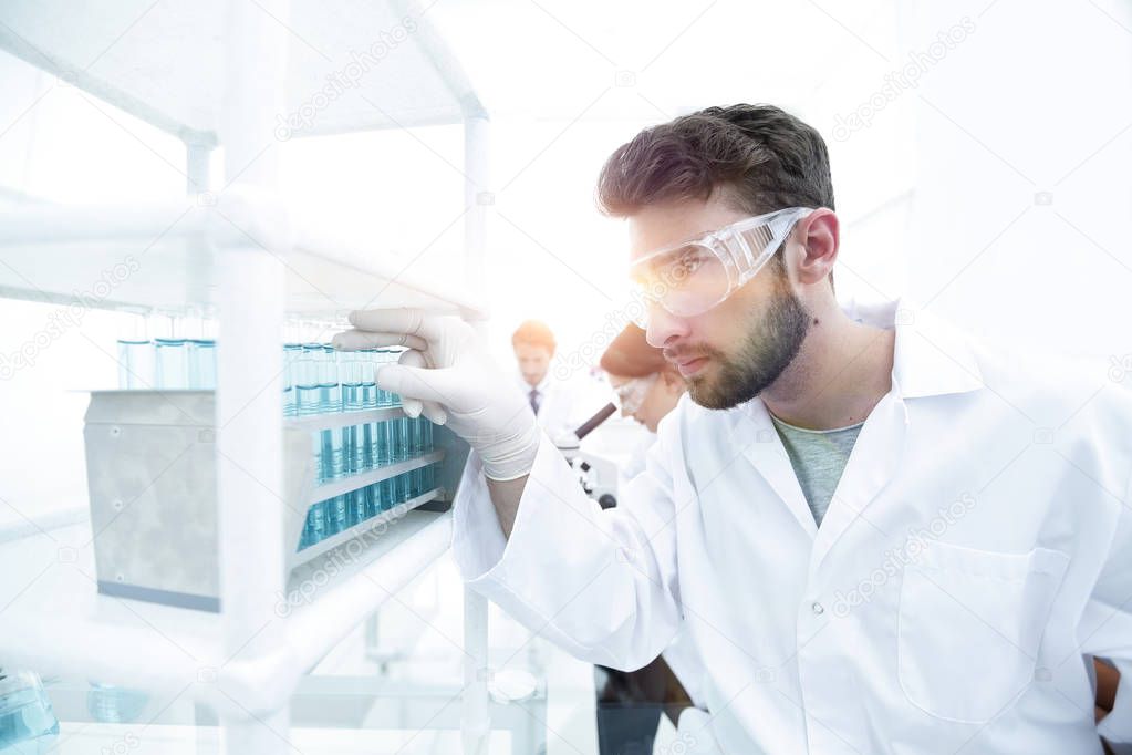 A young man doing an experiment in a chemical laboratory