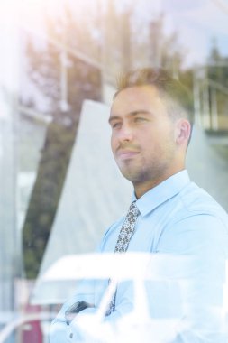 Camların arkasından manzara. Kendine güvenen iş adamı ofisinin penceresinden dışarı bakıyor.