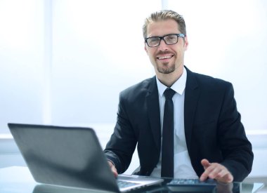 İşadamı laptopta çalışıyor.