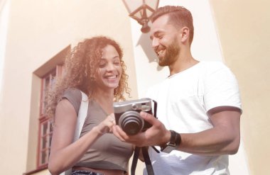 Fotoğraflara bakarak yürüyen genç arkadaşların portresi