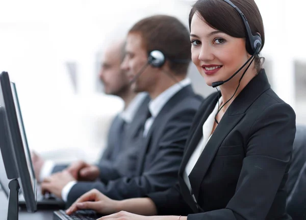 Agente de atendimento ao cliente feminino com fone de ouvido trabalhando em um call center — Fotografia de Stock