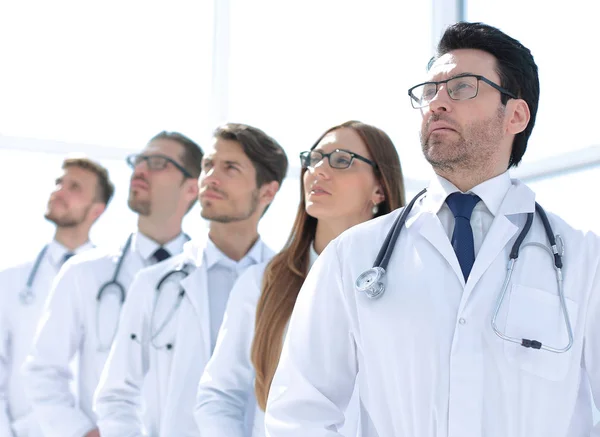 Gruppe von Ärzten steht in einer Reihe und betrachtet einen Kopierraum — Stockfoto