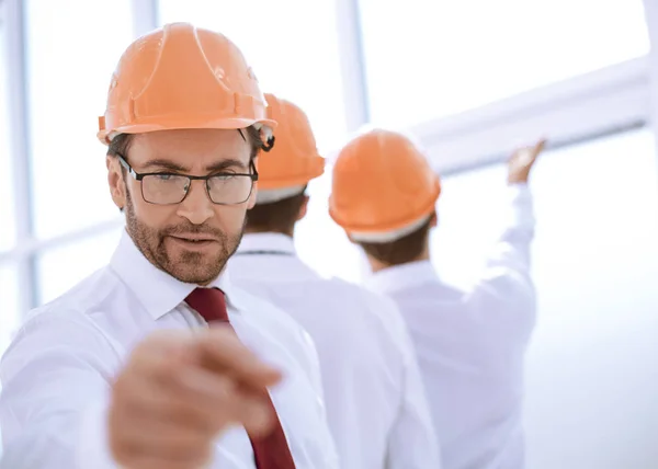 Close up. Business man in a protective helmet pointing at you — стоковое фото