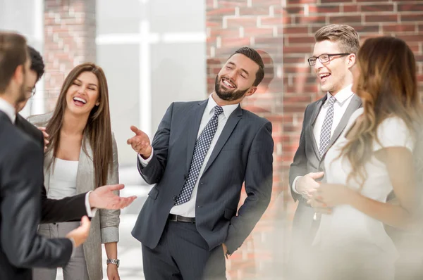 Leende personal diskutera något i office korridoren — Stockfoto