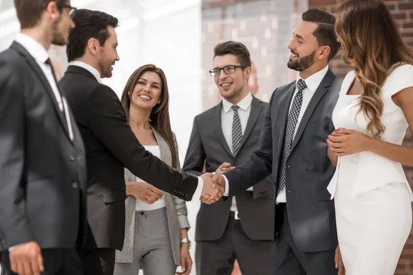 Sonriente gente de negocios estrechando la mano entre sí — Foto de Stock