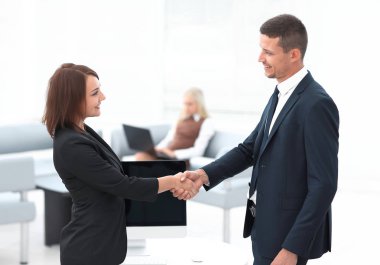 Pazarlık masasında el sıkışan iş ortakları.