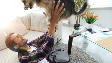 şık adam köpeğiyle tarafından geniş bir oturma odası oturma oynarken.