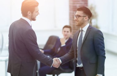 İki işadamı büyük bir anlaşma yaptıktan sonra el sıkışıyor.