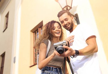 Fotoğraflara bakarak yürüyen genç arkadaşların portresi