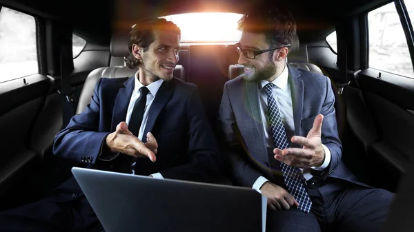 Dois homens de negócios conversando enquanto sentados no carro — Fotografia de Stock