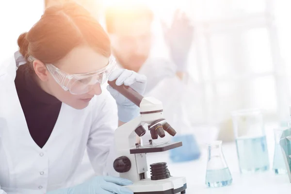 Female scientists looking into a microscope — Stock Photo, Image