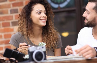 Genç kadının sıcak yaz güneşte sokak bir kafede yemek