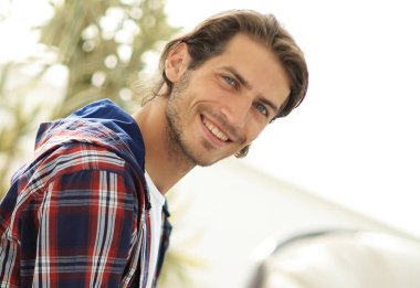 dizüstü bilgisayarda çalışan ve kameraya bakarak şık genç adam