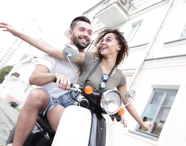 Красивая молодая пара улыбается во время езды на скутере — стоковое фото