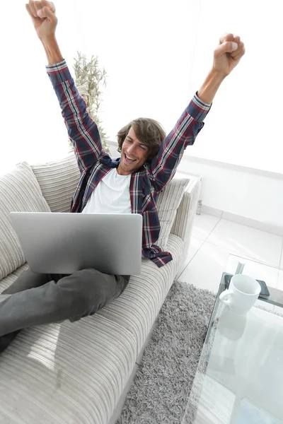 Mycket glad kille arbetar med laptop hemma. — Stockfoto