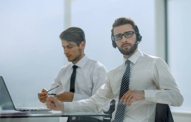 Kulaklıklı müdür modern bir ofiste çalışıyor.