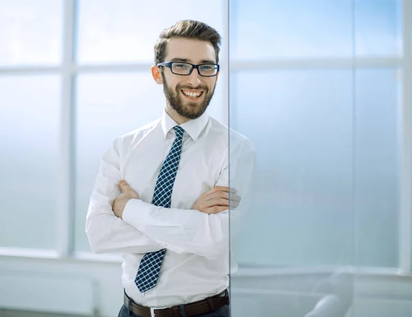 Uomo d'affari sorridente in piedi vicino alla finestra dell'ufficio . — Foto Stock