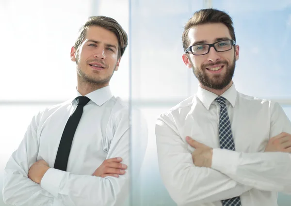 Collègues d'affaires souriants debout dans un bureau lumineux — Photo