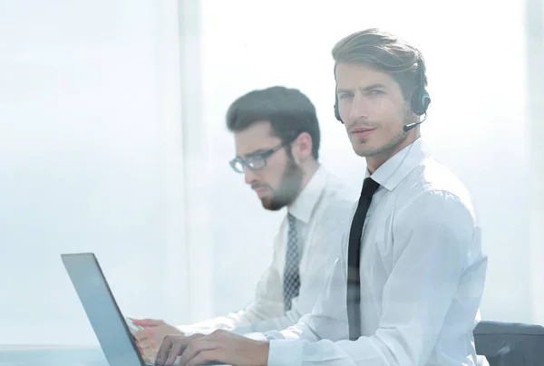 Manager med headset använder en bärbar dator för att arbeta med klienten — Stockfoto