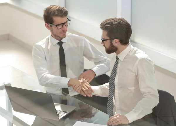 Stäng up.employees skakar hand på skrivbordet — Stockfoto