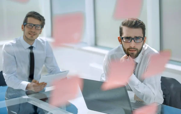 Två tankeväckande anställda sitta vid ett skrivbord. — Stockfoto