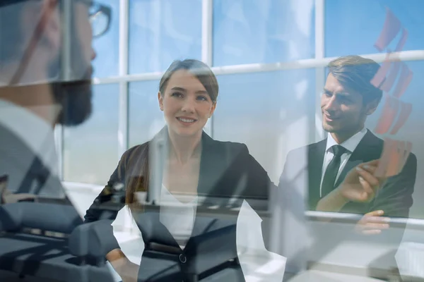 Stäng up.employees på bakgrunden av ett modernt kontor — Stockfoto