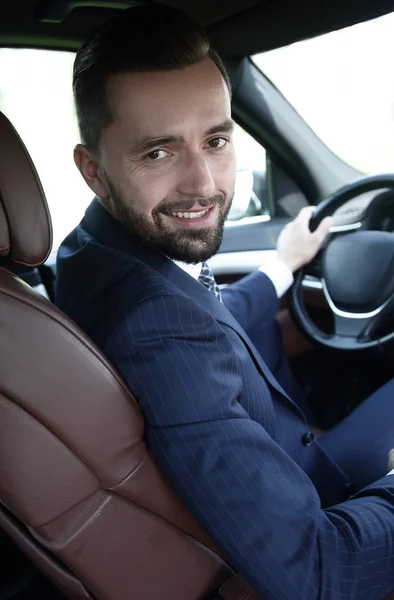 Businessman sitting at the wheel of a prestigious car — Stock Photo, Image