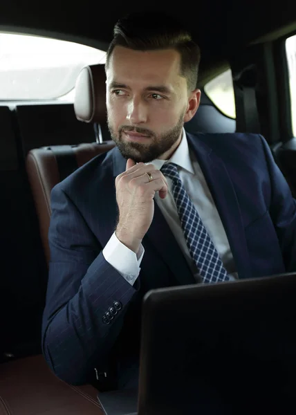 快適な車に座ってノート パソコンを持つビジネスマン — ストック写真