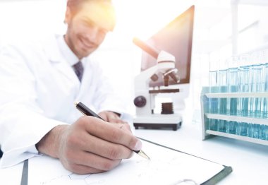 Bilimadamı laboratuarda bir deney notu yazar.