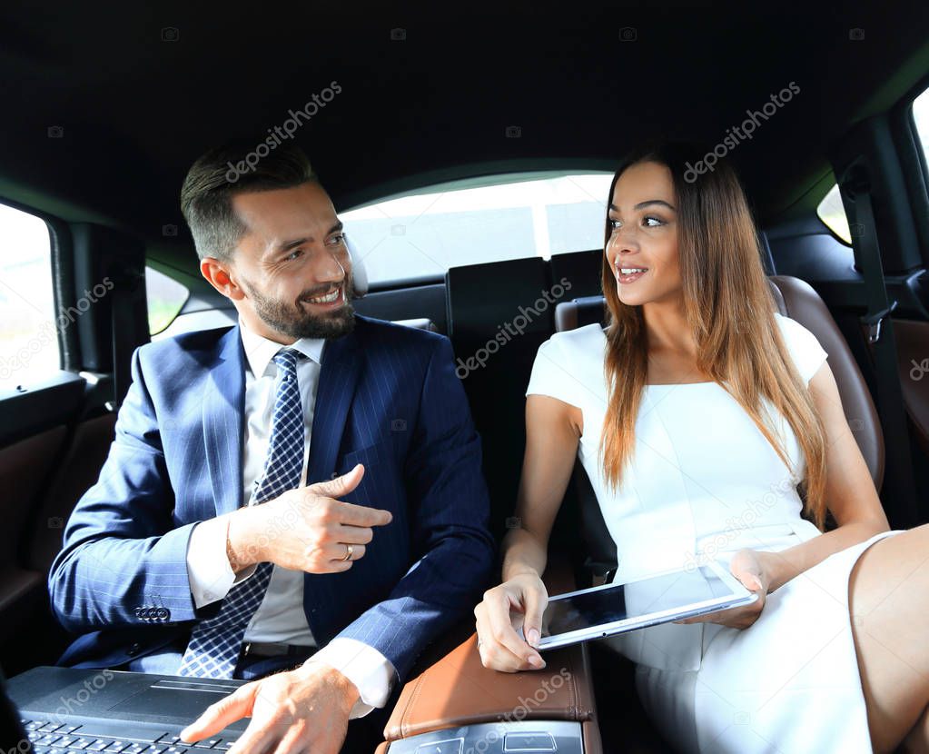 successful people working together in back seat of car