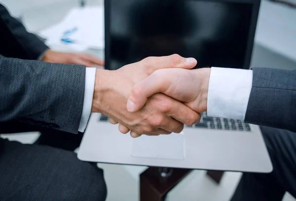 Cerrar up.handshake socios comerciales sobre el escritorio . — Foto de Stock