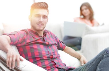 büyük sandalyede oturan genç adam