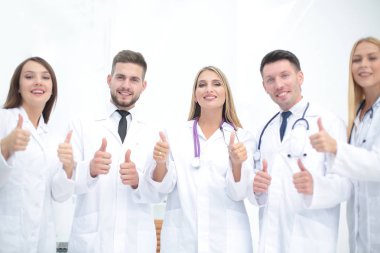 Bir doktor ve tıbbi ekip başparmak gösterilmesini portre
