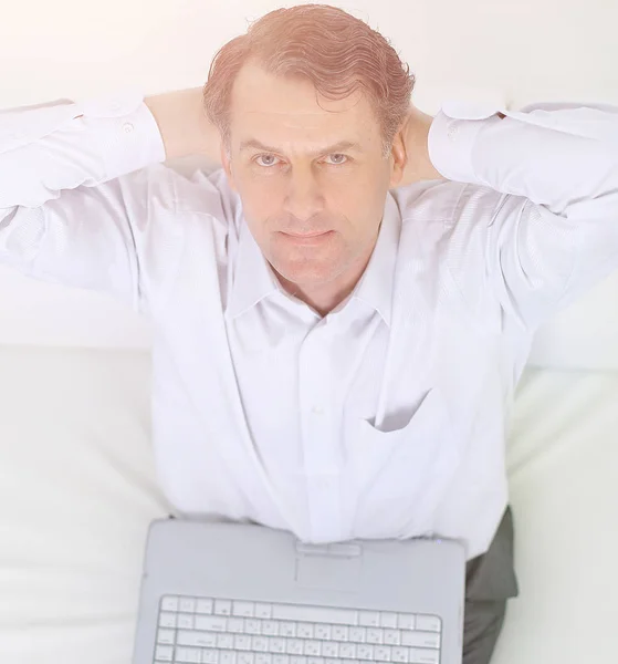 Closeup.the view from the top.man with laptop lying on sofa — Stock Photo, Image