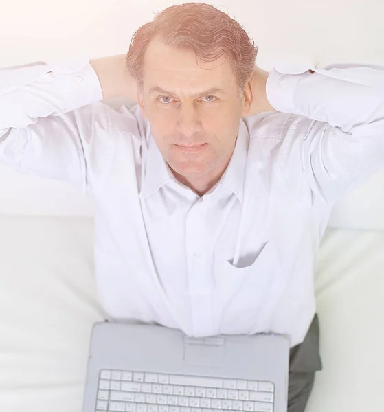 Primo piano.la vista dal top.man con computer portatile sdraiato sul divano — Foto Stock