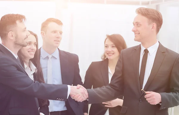 Equipe de negócios olha para os parceiros de negócios handshake — Fotografia de Stock