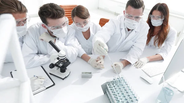 Médicos están trabajando con tubos de ensayo y microscopio en el laboratorio — Foto de Stock