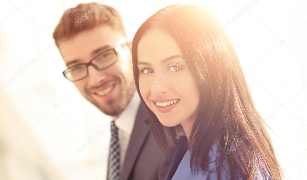cheerful business couple looking at file indoors.