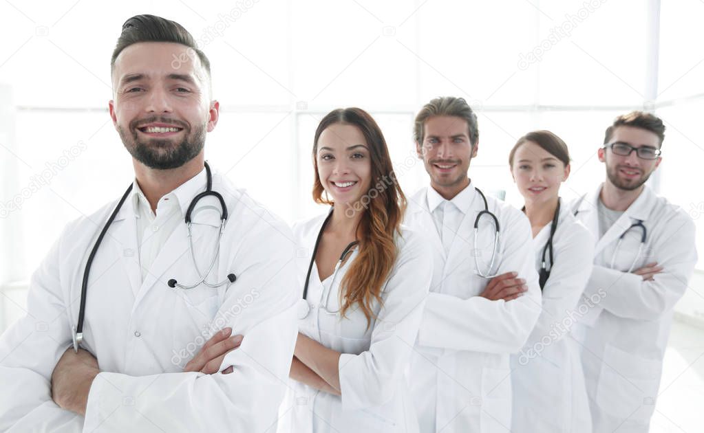 Group of happy successful doctors standing in a row in the hospital