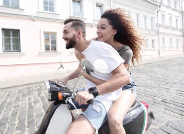 mutlu genç bir çift bir scooter üzerinde eğleniyor