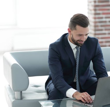 İşadamı kanepede oturan belgelerle çalışma.