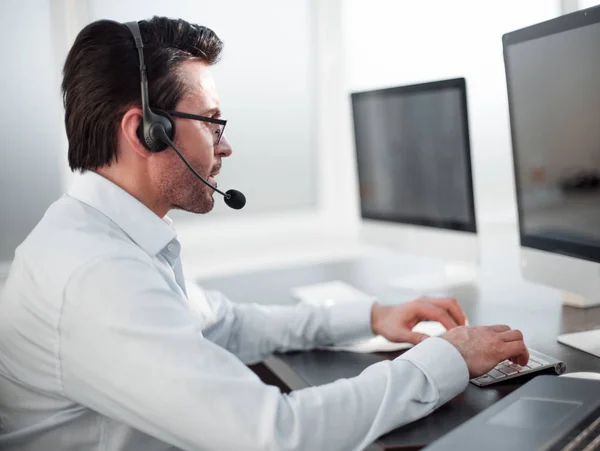 Nahaufnahme. Geschäftsmann mit Headset arbeitet in einem modernen Büro — Stockfoto