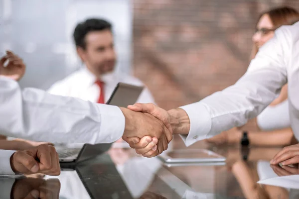 Handslag för affärspartners på bakgrunden av desktopen — Stockfoto