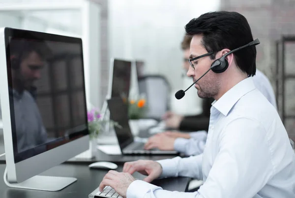 Group of business colleagues with headsets using computers at office desk — Stock Photo, Image