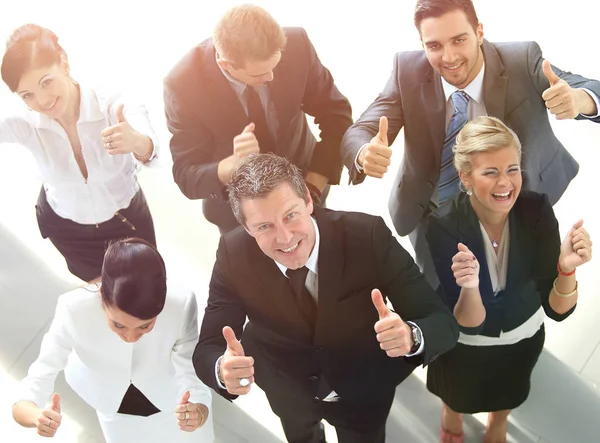 Vista de cima. equipe de negócios feliz mostrando polegar para cima . — Fotografia de Stock