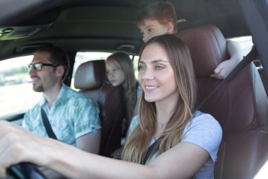 yakın çekim. Arabada seyahat çocuklu genç bir aile