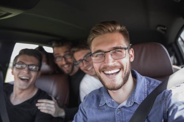 Dört arkadaş arabada seyahat ediyor.