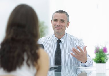 İş danışmanı masasında oturur ve müşteri ile başvurun