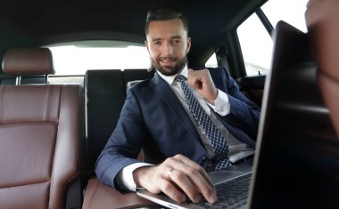 iş adamı arabaya otururken dizüstü bilgisayarda okur